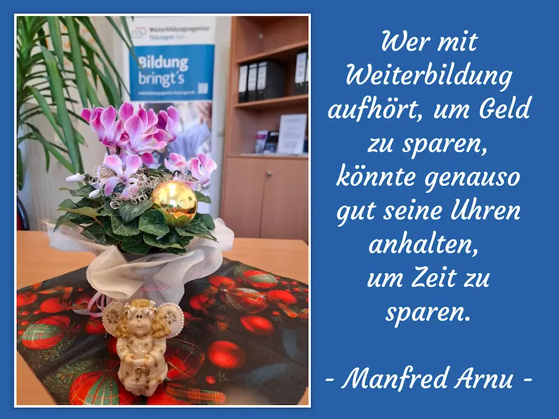 Blumentopf mit rosa Alpenveilchen, goldener Weihnachtskugel und Engel-Figur auf Tisch mit weihnachtlicher Tischdecke, im Hintergrund ein blauer Banner der Weiterbildungsagentur Thüringen und ein Regal mit Ordnern, daneben weißer Text mit Zitat von Manfred Arnu