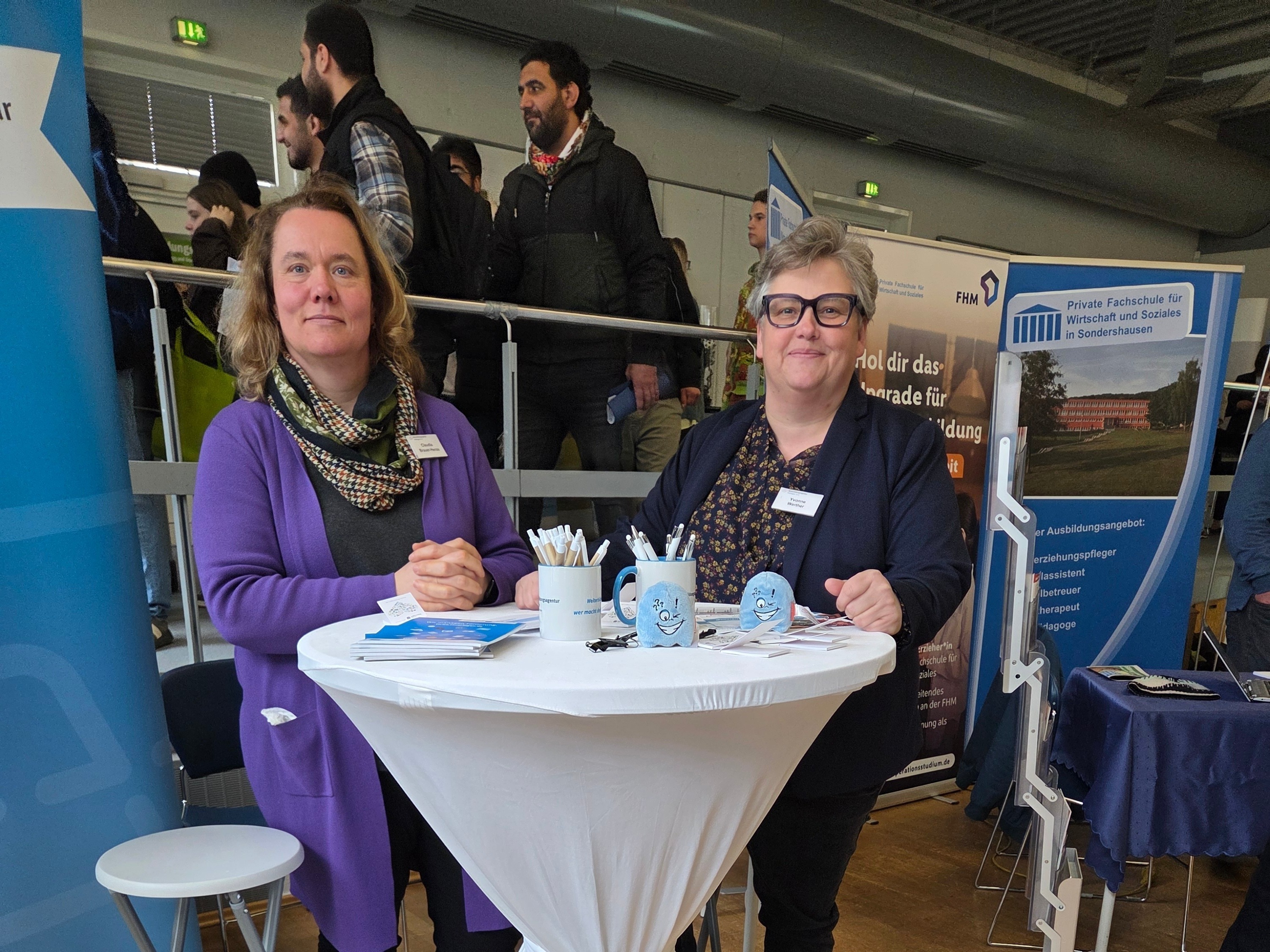 Messestand der Weiterbildungsagentur Thüringen mit zwei Beraterinnen und vielen Besuchern im Hintergrund