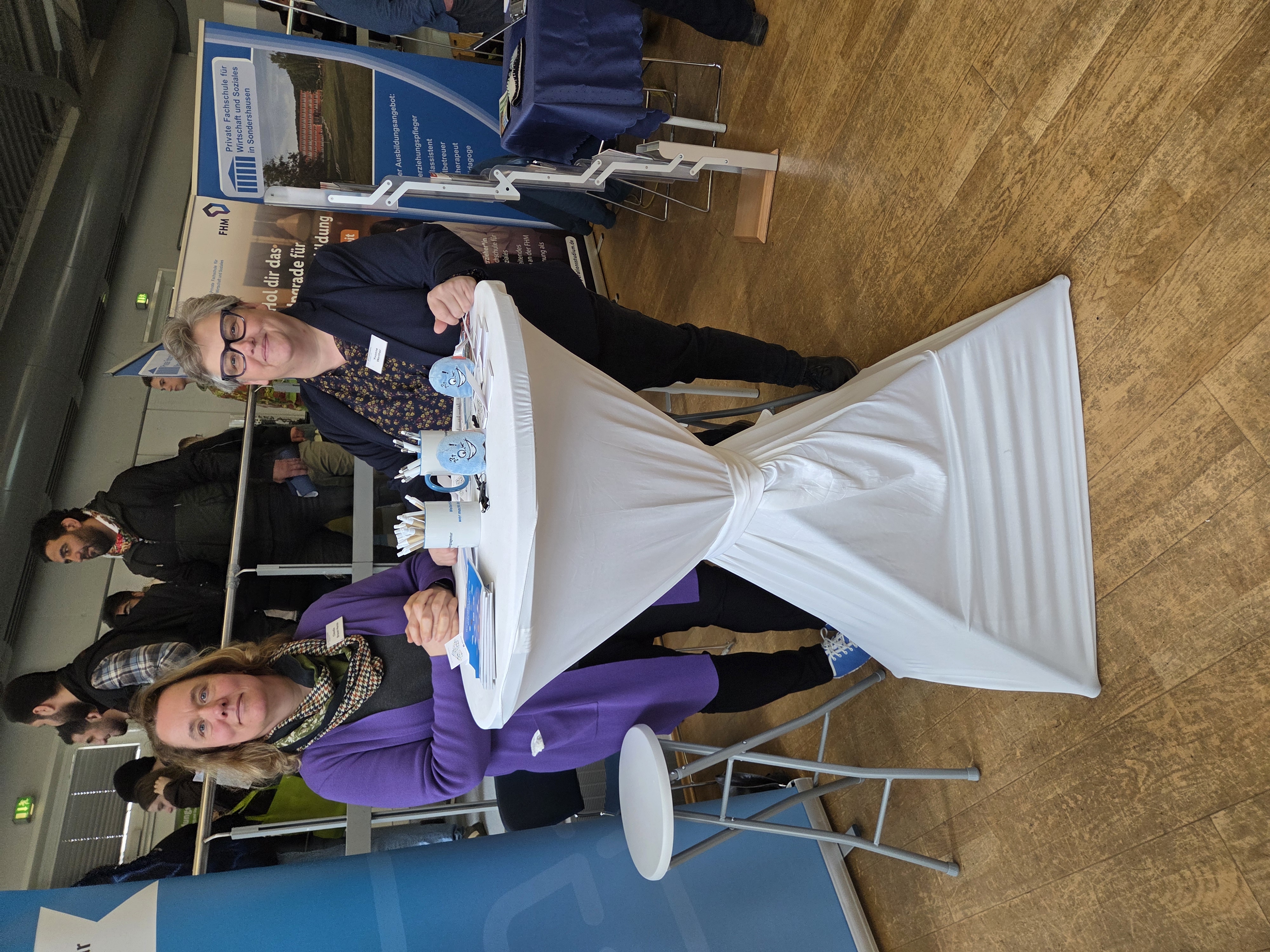 Messestand der Weiterbildungsagentur Thüringen mit zwei Beraterinnen und vielen Besuchern im Hintergrund