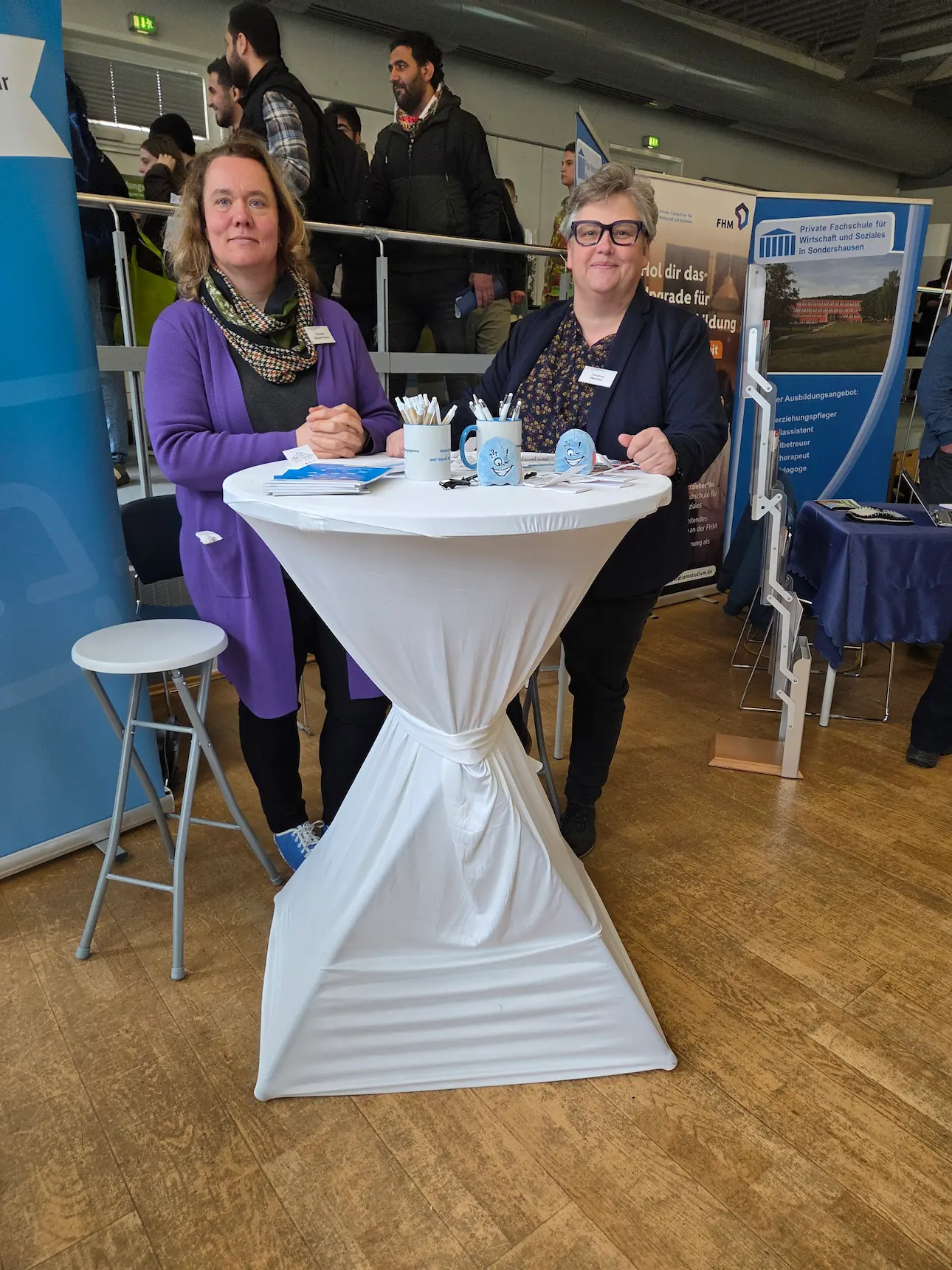 Messestand der Weiterbildungsagentur Thüringen mit zwei Beraterinnen und vielen Besuchern im Hintergrund